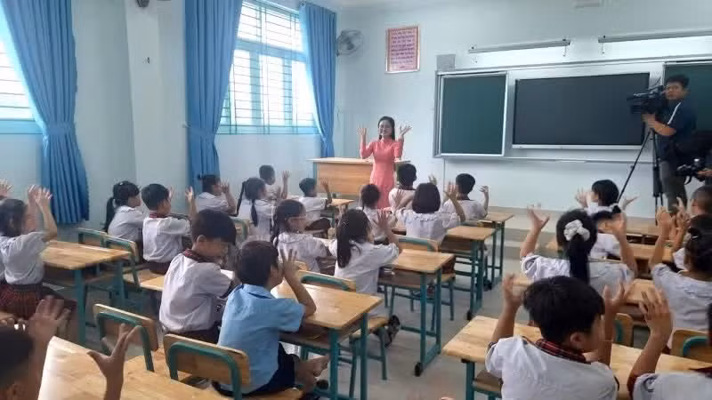 Primary school pupils listen as teachers at Tran Dai Nghia Primary School introduce the new campus.