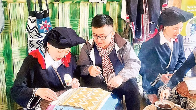 Visitors experience the traditional craft of creating beeswax patterns at the community tourism site of Sung village, Cao Son commune.