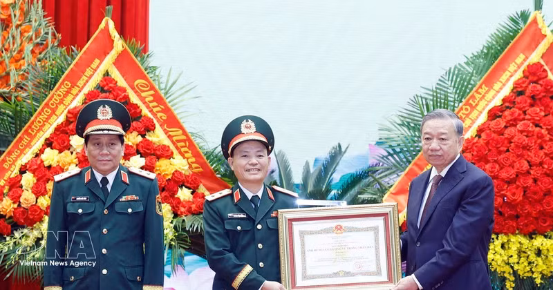 Party General Secretary and State President To Lam (right), who is also Secretary of the Central Military Commission, presents the "Hero of the People’s Armed Forces" title to representatives of Military Region 3 on April 10. (Photo: VNA)