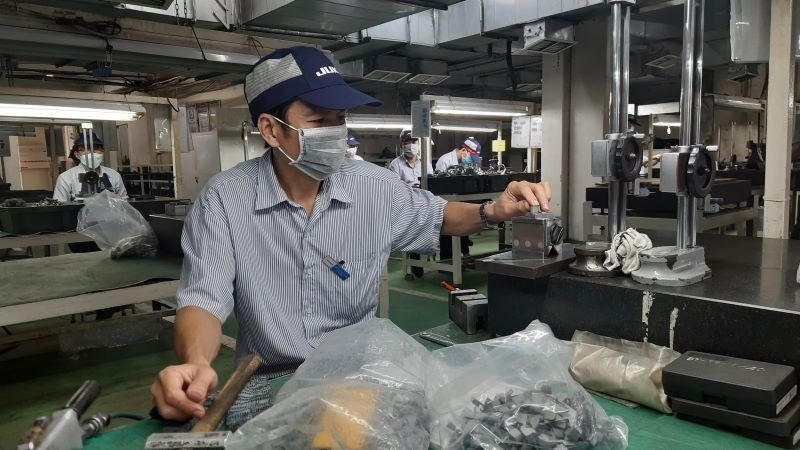 Workers at Juki Vietnam Co., Ltd., Tan Thuan Export Processing Zone, Ho Chi Minh City are manufacturing industrial sewing machine components.