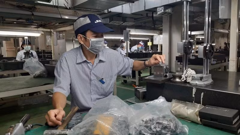 Workers at Juki Vietnam Co., Ltd., Tan Thuan Export Processing Zone, Ho Chi Minh City are manufacturing industrial sewing machine components.
