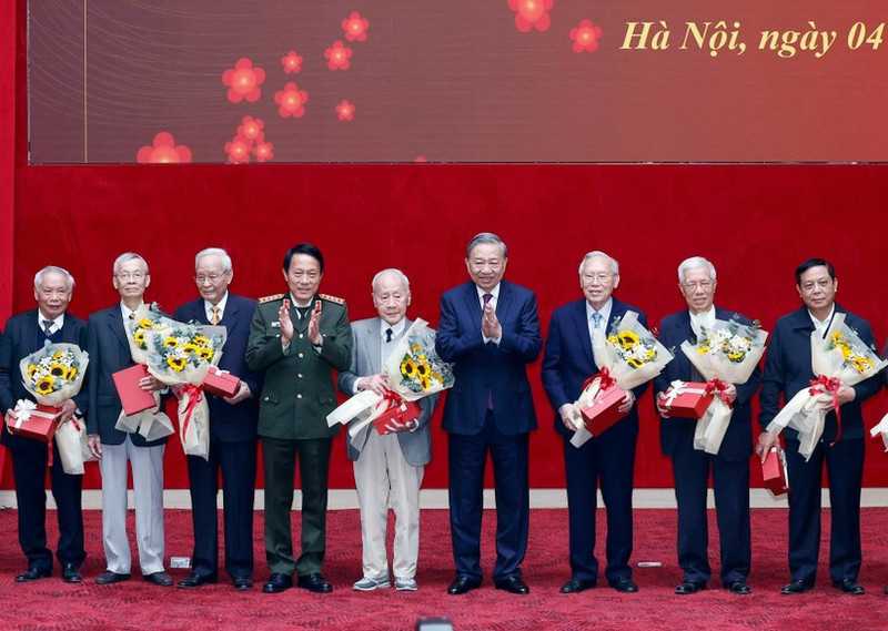 Party General Secretary To Lam (fourth, right) and Minister of Public Security General Luong Tam Quang (fourth, left) present flowers and gifts to former public security officers. (Photo: VNA)