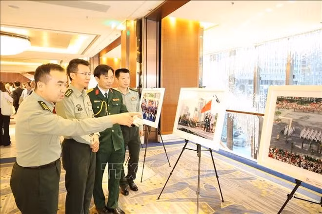 Guests tour a photo exhibition on Viet Nam’s land and people held during the event (Photo: VNA)