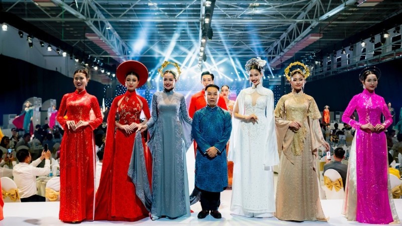 Designer Nguyen Viet Hung and models present a collection of traditional ao dai for Vietnamese women, created using Thai Tuan fabric.