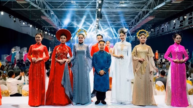 Designer Nguyen Viet Hung and models present a collection of traditional ao dai for Vietnamese women, created using Thai Tuan fabric.