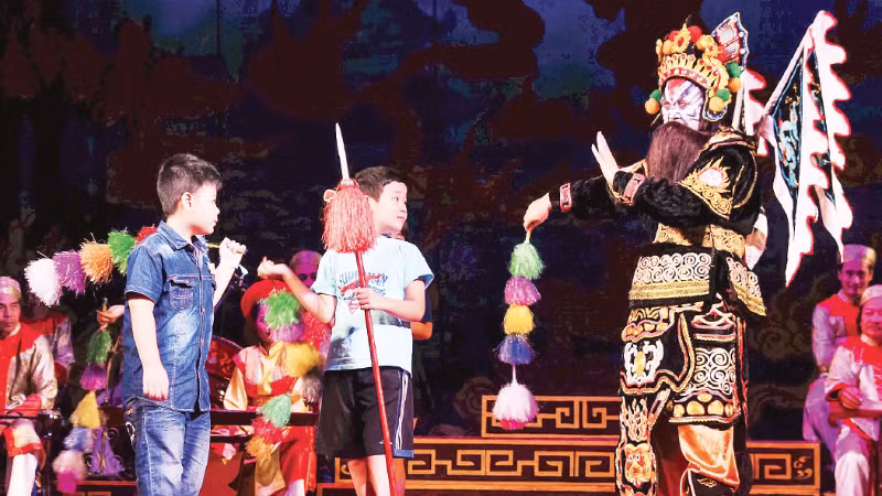 Children from the “Reading Books with Children” Club experience tuong (classical drama) stage props. (Photo: Reading Books with Children Club)