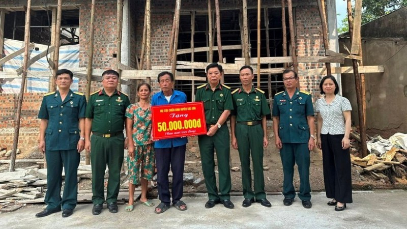 Veteran Pham Van Luong (centre) receives support to build a new home. (Photo: NGOC LAN)