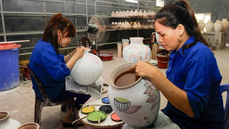 Painting patterns on ceramic products at Bat Trang Pottery Village. (Photo: DANG ANH)