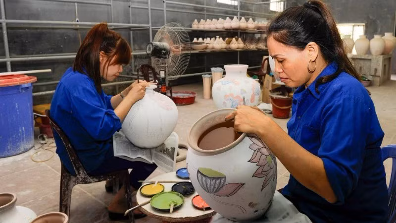 Painting patterns on ceramic products at Bat Trang Pottery Village. (Photo: DANG ANH)