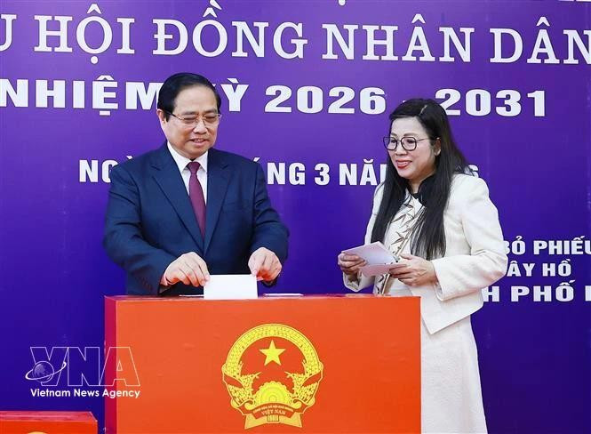 Prime Minister Pham Minh Chinh and his spouse cast ballots at Polling Station No. 21 in Tay Ho ward, Ha Noi, on March 15 morning. (Photo: VNA)