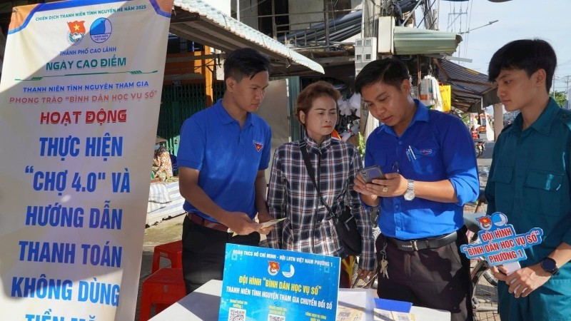 Youth union members guide vendors on cashless payments at My Ngai Market, Ward 1, Cao Lanh City.
