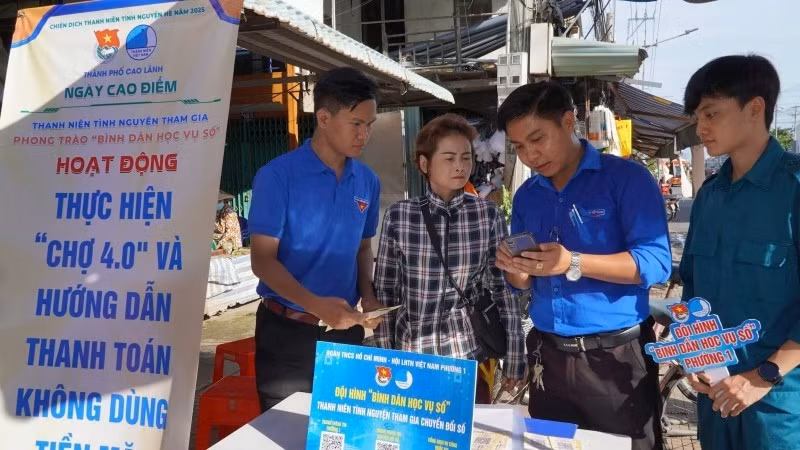 Youth union members guide vendors on cashless payments at My Ngai Market, Ward 1, Cao Lanh City.
