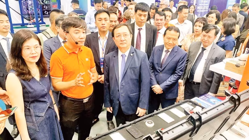 Scientists visit a technology product exhibition area at the Viet Nam Technology and Innovation Connectivity event.