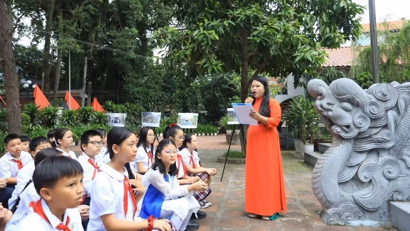 Pupils at Xuan La Primary School (Ha Noi) study local history at the Quan La Communal House, a heritage site. (Photo: GIANG NAM)