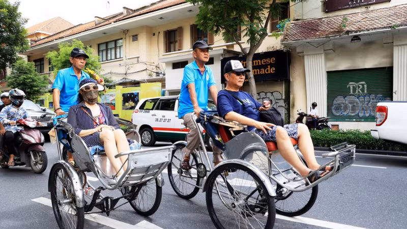 Japanese tourists explore the centre of Ho Chi Minh City by cyclo. (Photo: VNA)