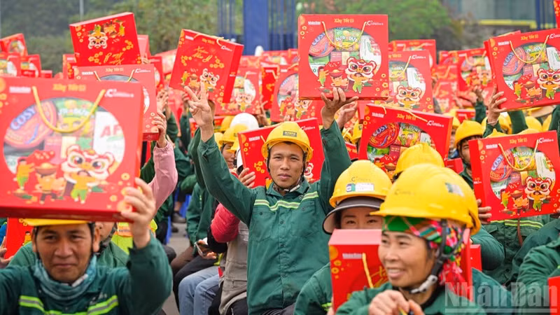 Workers at the construction site of the Ngoc Trai Theatre project (Ha Noi) joyfully receive Tet gifts from the organisers of the “Building Tet 2026” programme. (Photo: Nhan Dan Newspaper)