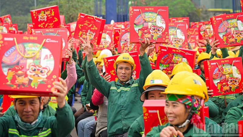 Workers at the construction site of the Ngoc Trai Theatre project (Ha Noi) joyfully receive Tet gifts from the organisers of the “Building Tet 2026” programme. (Photo: Nhan Dan Newspaper)