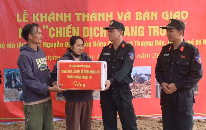 Lieutenant Colonel Pham Hong Phuc (right) from Mobile Police Command congratulates a couples in Thuong Duc commune, Da Nang city, on their new house built by the police force. (Photo: VNA)