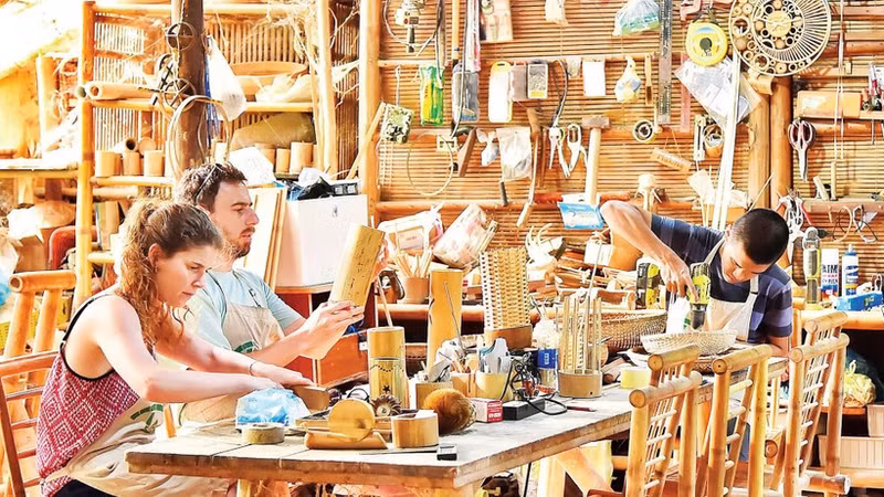 Visitors make bamboo souvenir products at a handicraft facility in Da Nang. (Photo: MY HA)