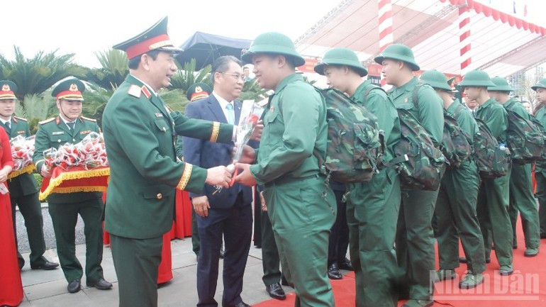 General Phan Van Giang, Minister of National Defence, presents flowers to new recruits heading off to perform their duties.