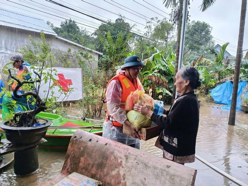 A representative of the Viet Nam Red Cross Society delivers relief to a flood-hit resident in Hue city. (Photo: VNA)