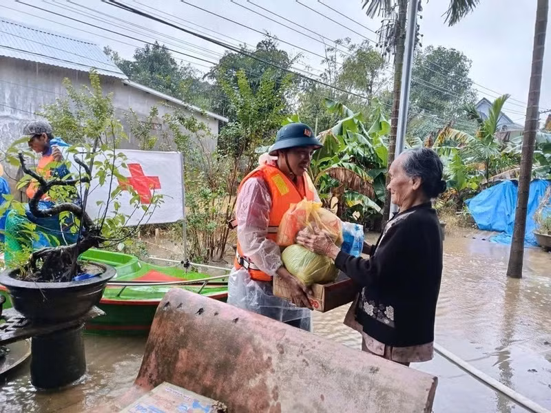 A representative of the Viet Nam Red Cross Society delivers relief to a flood-hit resident in Hue city. (Photo: VNA)