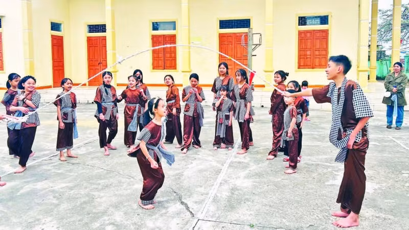 Children from the “Anchoring the soul of Vi and Giam” class during a roots-return activity, taking part in traditional folk games.