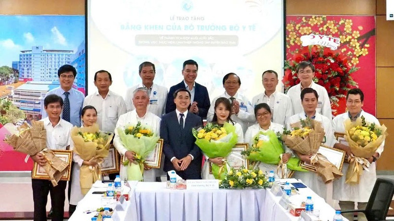 Deputy Minister of Health Tran Van Thuan presents flowers and certificates of merit to the team who performed the fetal intervention for the Singaporean mother. (Photo: HOANG HUNG)