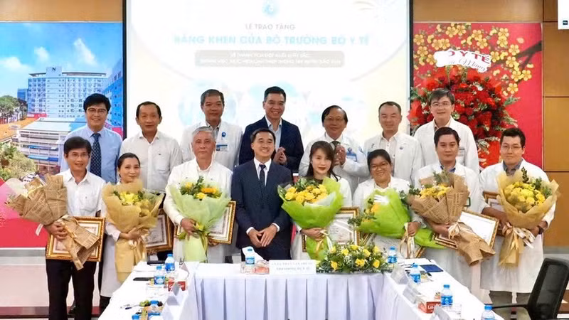 Deputy Minister of Health Tran Van Thuan presents flowers and certificates of merit to the team who performed the fetal intervention for the Singaporean mother. (Photo: HOANG HUNG)