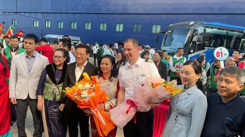 A representative of the Department of Culture, Sports and Tourism of Quang Ninh presents flowers to tourists arriving from Beihai (China).