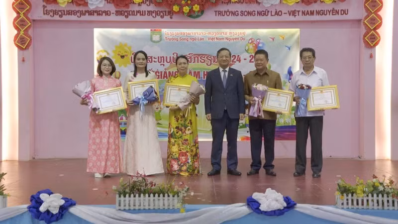 Vietnamese Ambassador to Laos Nguyen Minh Tam presents certificates of merit to the Vietnamese community in Vientiane and leaders of the Nguyen Du Lao-Vietnamese bilingual school for their contributions to preserving Vietnamese culture. (Photo: VNA)