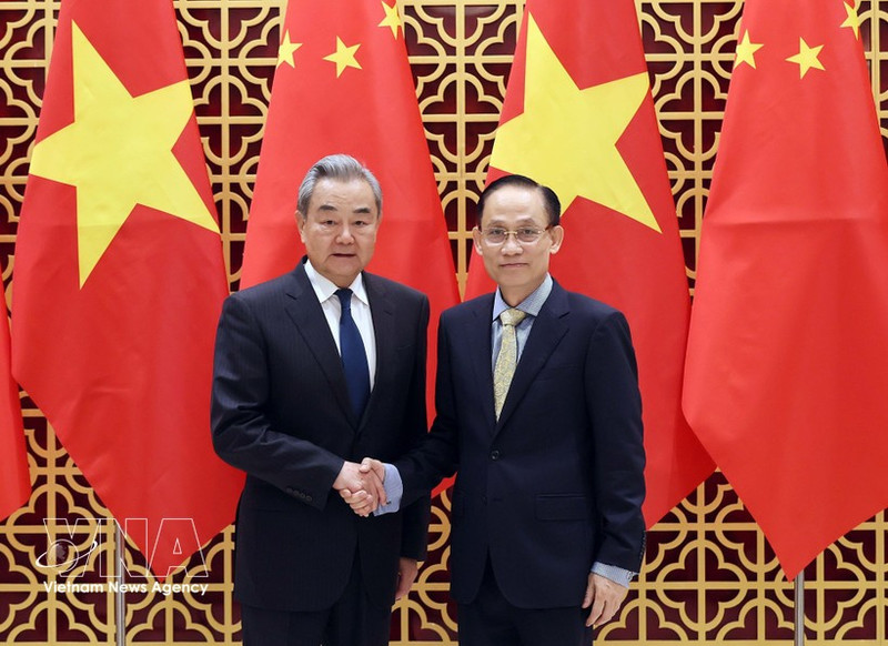 Vietnamese Politburo member and Minister of Foreign Affairs Le Hoai Trung (right) welcomes Chinese Politburo member and Minister of Foreign Affairs Wang Yi in Ha Noi on March 15. (Photo: VNA)