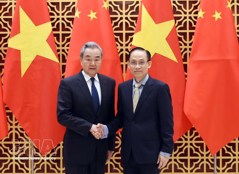 Vietnamese Politburo member and Minister of Foreign Affairs Le Hoai Trung (right) welcomes Chinese Politburo member and Minister of Foreign Affairs Wang Yi in Ha Noi on March 15. (Photo: VNA)