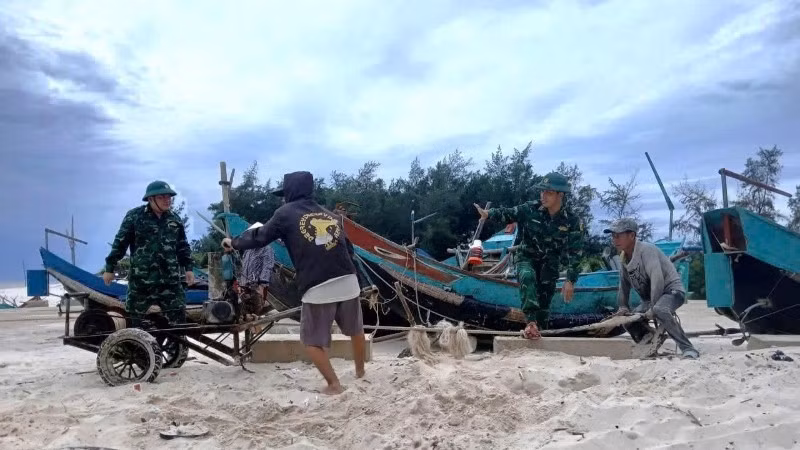 Officers and soldiers of Roon Border Guard Station (Quang Tri Province) help locals pull and move fishing boats ashore.