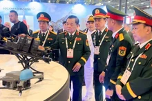 Senior Lieutenant General Hoang Xuan Chien visits various booths with delegates.