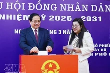 Prime Minister Pham Minh Chinh and his spouse cast ballots at Polling Station No. 21 in Tay Ho ward, Ha Noi, on March 15 morning. (Photo: VNA)
