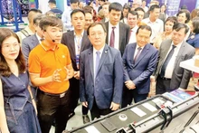 Scientists visit a technology product exhibition area at the Viet Nam Technology and Innovation Connectivity event.