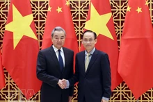 Vietnamese Politburo member and Minister of Foreign Affairs Le Hoai Trung (right) welcomes Chinese Politburo member and Minister of Foreign Affairs Wang Yi in Ha Noi on March 15. (Photo: VNA)