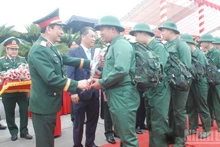 General Phan Van Giang, Minister of National Defence, presents flowers to new recruits heading off to perform their duties.
