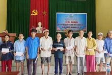 Representatives of Nhan Dan Newspaper in Quang Tri hand over cash donations to households in Hoi Ky Hamlet, Nam Hai Lang Commune.
