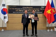 Park Hyeon Guk, Head of Bonghwa County (the RoK), presents an insignia to Vu Ho, Vietnamese Ambassador to the RoK.