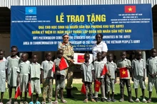 Lieutenant Colonel Tran Thanh Son, Deputy Commander of Viet Nam’s Engineering Unit No. 4, presents school supplies to Abyei students. (Photo: HAI YEN)