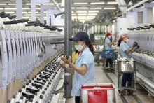 Workers at Hoang Thi Loan Garment Joint Stock Company operate a production line. (Photo: MAI HOA)