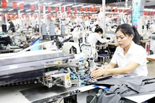 An automatic steam press valued at more than 1.3 billion VND — one of the most modern pieces of equipment at Hung Ha Veston Enterprise (under May 10 Corporation, Hung Ha Commune, Hung Yen Province) — is operated by workers. Photo: THE DUYET