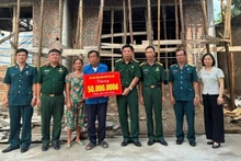 Veteran Pham Van Luong (centre) receives support to build a new home. (Photo: NGOC LAN)