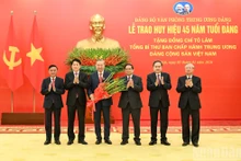 Party General Secretary To Lam (third, left) is awarded the 45-year Party membership badge. (Photo: nhandan.vn)