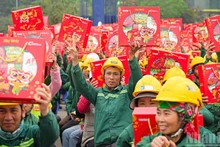 Workers at the construction site of the Ngoc Trai Theatre project (Ha Noi) joyfully receive Tet gifts from the organisers of the “Building Tet 2026” programme. (Photo: Nhan Dan Newspaper)