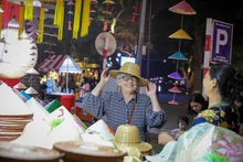 An international visitor delights in Viet Nam’s traditional products while exploring Ha Noi (Photo: VNA)