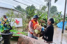 A representative of the Viet Nam Red Cross Society delivers relief to a flood-hit resident in Hue city. (Photo: VNA)