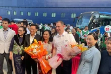 A representative of the Department of Culture, Sports and Tourism of Quang Ninh presents flowers to tourists arriving from Beihai (China).